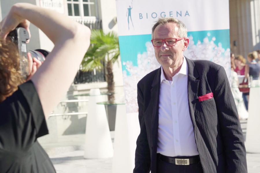 Prof. Dr. Dr. Beyreuther wird von einem Fotografen beim Biogena Akademie VIP Event fotografiert