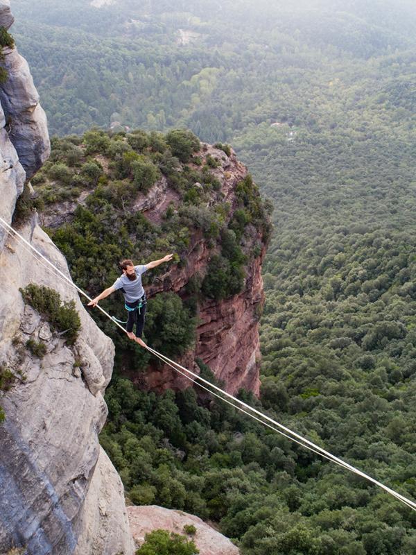 Mann balanciert zwischen zwei Bergen in der Natur
