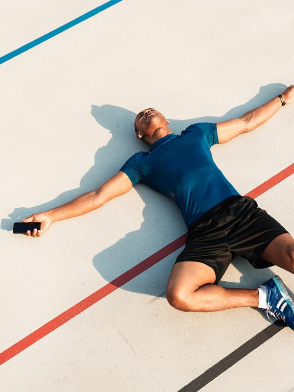 Läufer liegt total ausgepowert auf dem Boden