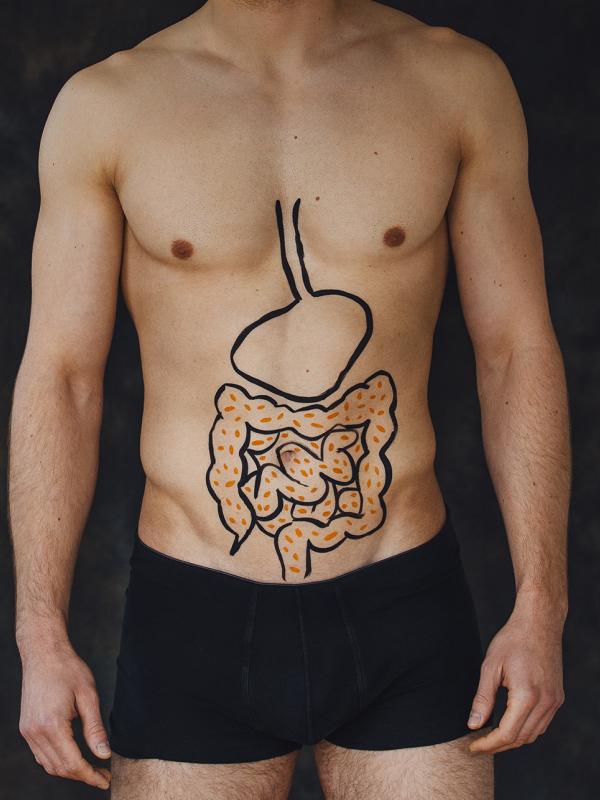 Mann mit aufgezeichnetem Darm auf Bauch