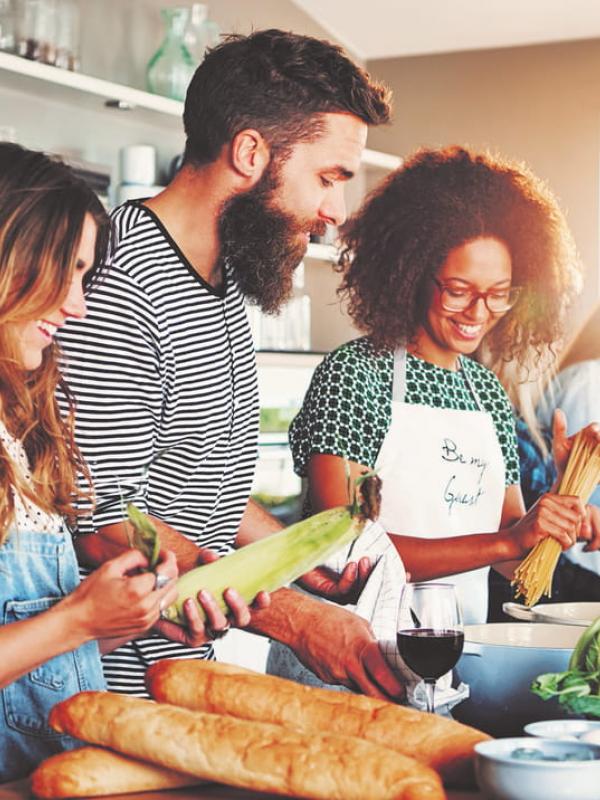 Lustige Gruppe kocht gemeinsam gesundes und ausgewogenes Essen
