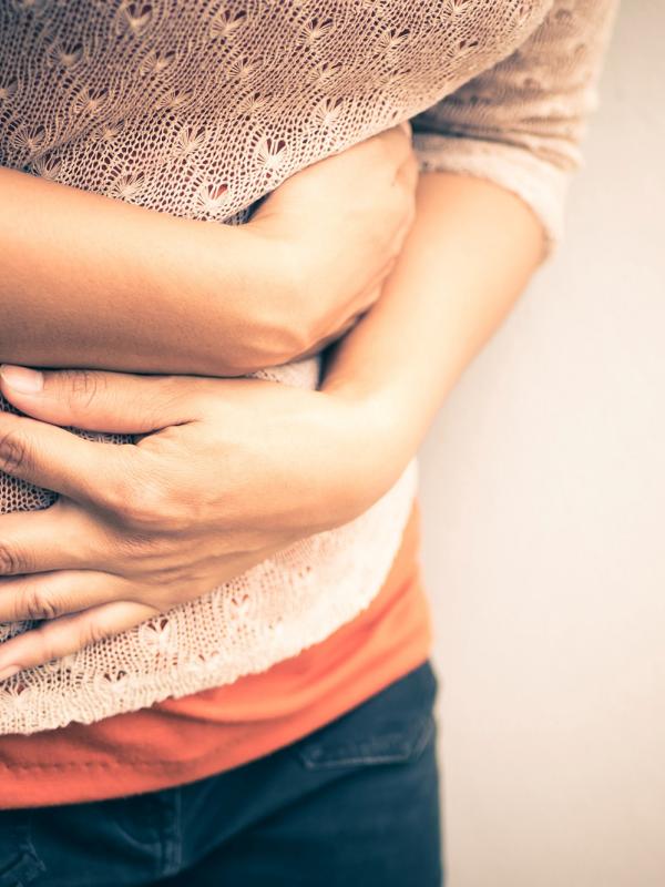 Frau hält sich vor Schmerzen den Bauch